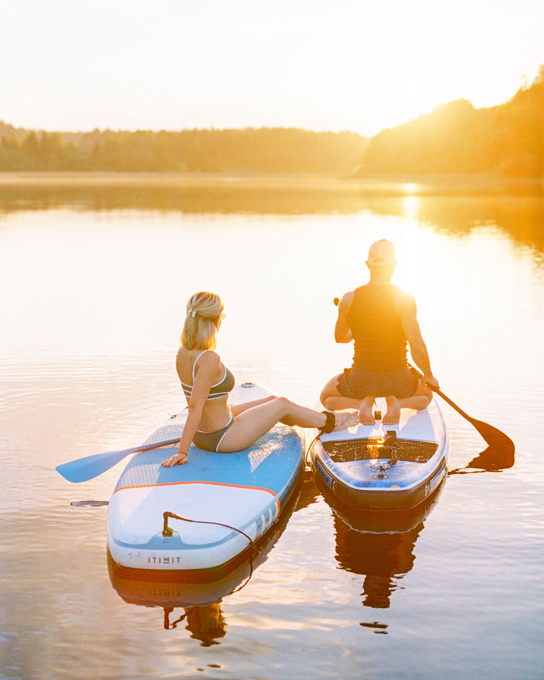 man and woman paddleboarding